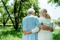 View retired man hugging senior happy wife in green park Royalty Free Stock Photo