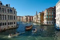 View from the Rialto Bridge with facades of picturesque old buildings on the Grand Canal, gondolas and boats in Venice. Sunny Royalty Free Stock Photo