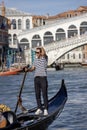 View on Rialto Bridge (Ponte de Rialto) on Grand Canal and gondola with tourist, Venice, Italy