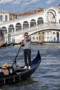 View on Rialto Bridge (Ponte de Rialto) on Grand Canal and gondola with tourist, Venice, Italy