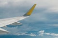 View of right wing from window of airplane flying up in the sky, through clouds in atmosphere. Plane in flight. Up in the air.