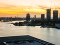 View of a river with Adam tower and modern buildings in the background during sunset, Amsterdam