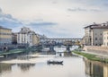 View of the river Arno, Ponte Vecchio bridge and pleasure boats in Florence in the evening