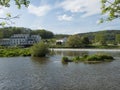 View on the river Berounka in village Zadni Treban with weir and building of Hotel Mlyn Karlstejn, sunny summer day