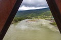 View of a river flowing in a valley surrounded by greenery with clouds over mountains in Bhutan. Royalty Free Stock Photo