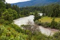 View of a river flowing in a valley surrounded by greenery with clouds over mountains in Bhutan. Royalty Free Stock Photo