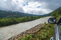 View of a river flowing in a valley surrounded by greenery with clouds over mountains in Bhutan. Royalty Free Stock Photo