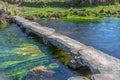 View of a river, with old and archaic stone bridge for pedestrian passage Royalty Free Stock Photo