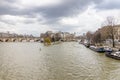 View of the river Seine and the arrow of the island of Cite in Paris on a cloudy winter day. The Pont Neuf New Bridge is the Royalty Free Stock Photo