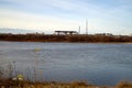 View of the river water and the factory on the other side with snow on a cloudy winter day Royalty Free Stock Photo