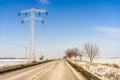 View of a road in the snowy landscape with an overhead power line by the side in Bucharest, Romania Royalty Free Stock Photo