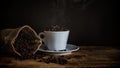 View of roasted dark coffee beans on coffee cup freshly roasted beans in jute burlap bag still life photography Royalty Free Stock Photo