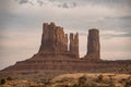 View of rock formations at Monument Valley with cloudy sky in background