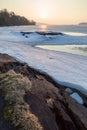 View of rock, frozen lake and cracked ice