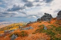 View of rocks and mountain taiga under clouds, autumn withered grass high in the mountains