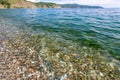 View of the rocky coast with clear transparent water near the shore of Lake Baikal Royalty Free Stock Photo