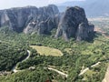 A view of rocky mountains with a serpentine road and green plants. Photography of the Meteora mountais, Greece