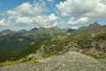 A view from a rocky peak at a picturesque mountain valley under a cloudy summer sky on a sunny warm day Royalty Free Stock Photo