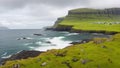 View on rocky seashore with white foam ocean and green moss stones on Faroe Islands