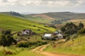 view of rolling hills with farmhouses and crops in the distance