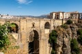 View of Ronda, Andalusian town situated atop spectacular deep gorge, with a massive stone bridge with arches, Spain