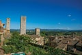 View of rooftops and towers with trees and blue sunny sky at San Gimignano. Royalty Free Stock Photo