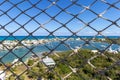 view through a rope fence of a tropical harbour and village Royalty Free Stock Photo