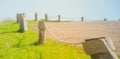 View of rope tired around wooden pole or pillar of fence beside road at countryside. Royalty Free Stock Photo