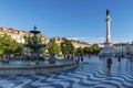 View of the Rossio Square with tourists walking by, in the pombaline downtown of the city of Lisbon Royalty Free Stock Photo