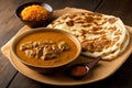 View of roti canai and lamb curry. The combination of the warm and crispy roti canai with the spicy and creamy lamb curry creates