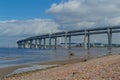 View of the rounded motorway highway bridge against a background of blue sky with clouds. The road passing over the sea bay near t