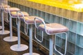 View of a row of bar stools that stand near a bar counter made of glass blocks. Concept interior, business, quarantine Royalty Free Stock Photo