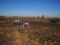 HIKERS ON A TRAIL ACROSS A BURNT OUT GRASSLAND