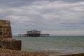 A view of the ruined West Pier from Brighton beach on a grey summer`s day Royalty Free Stock Photo