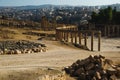 View ruins Oval Forum and long colonnaded street or cardo ancient Greco-Roman city Gerasa. Modern Jerash on background. Tourism in