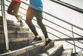 View of runners legs training outdoor - Sporty people running at sunset climbing city stairs - Focus on right shoes - Healthy