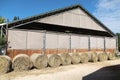 Hay bales are stacked in large stacks on an unknown riding centre Royalty Free Stock Photo