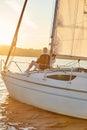 Time for yourself. View of the sail boat or yacht floating in sea with relaxed senior woman reading a book, sitting on Royalty Free Stock Photo