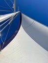 View of the sail and mast of sailing yacht against bright blue sky Royalty Free Stock Photo