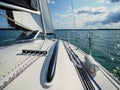 View on a sailboat bow of white sailing yacht on a lake during sailing in a summer sunny day