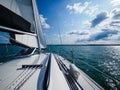 View on a sailboat bow of white sailing yacht on a lake during sailing in a summer sunny day Royalty Free Stock Photo