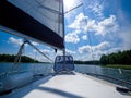 View on a sailing boat bow and sail, sailing on a lake in a sunny summer day Royalty Free Stock Photo