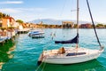 View on sailing yacht and boats parked on crystal clear blue water of amazing lake Garda and Toscolano Maderno cityscape on the