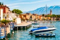 View on sailing yachts and boats parked on crystal clear blue water of amazing lake Garda and Toscolano Maderno cityscape on the