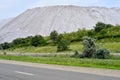 View of the salt mine and an artificial mound with green grass in the foreground