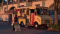 View of San Juan Food Truck selling Bolivan meals to pedestrians at English Bay Beach, Vancouver downtown in the evening light.