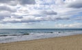 View from sand beach of mediteranean sea with waves and cloudy s Royalty Free Stock Photo