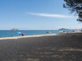 view of sand beach Spiaggia di Santa Maria Navarrese, sea with colorful beach umbrella and sunbeds and view of Arbatax Royalty Free Stock Photo