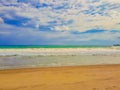 View from sand beach to wavy sea and cloud sky. Royalty Free Stock Photo