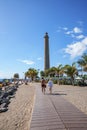 View of sandy beach and famous Maspalomas Lighthouse under blue sky